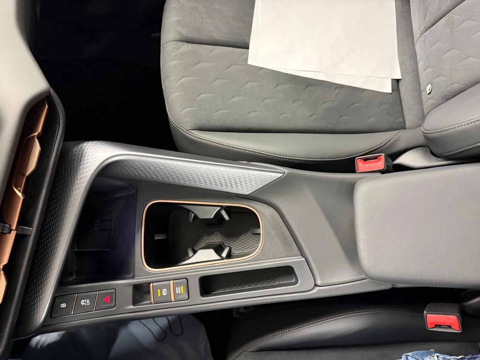 Vue plongeante sur la console centrale et les sièges avant gris du CUPRA TERRAMAR 1.5 eHybrid avec surpiqûres cuivrées.