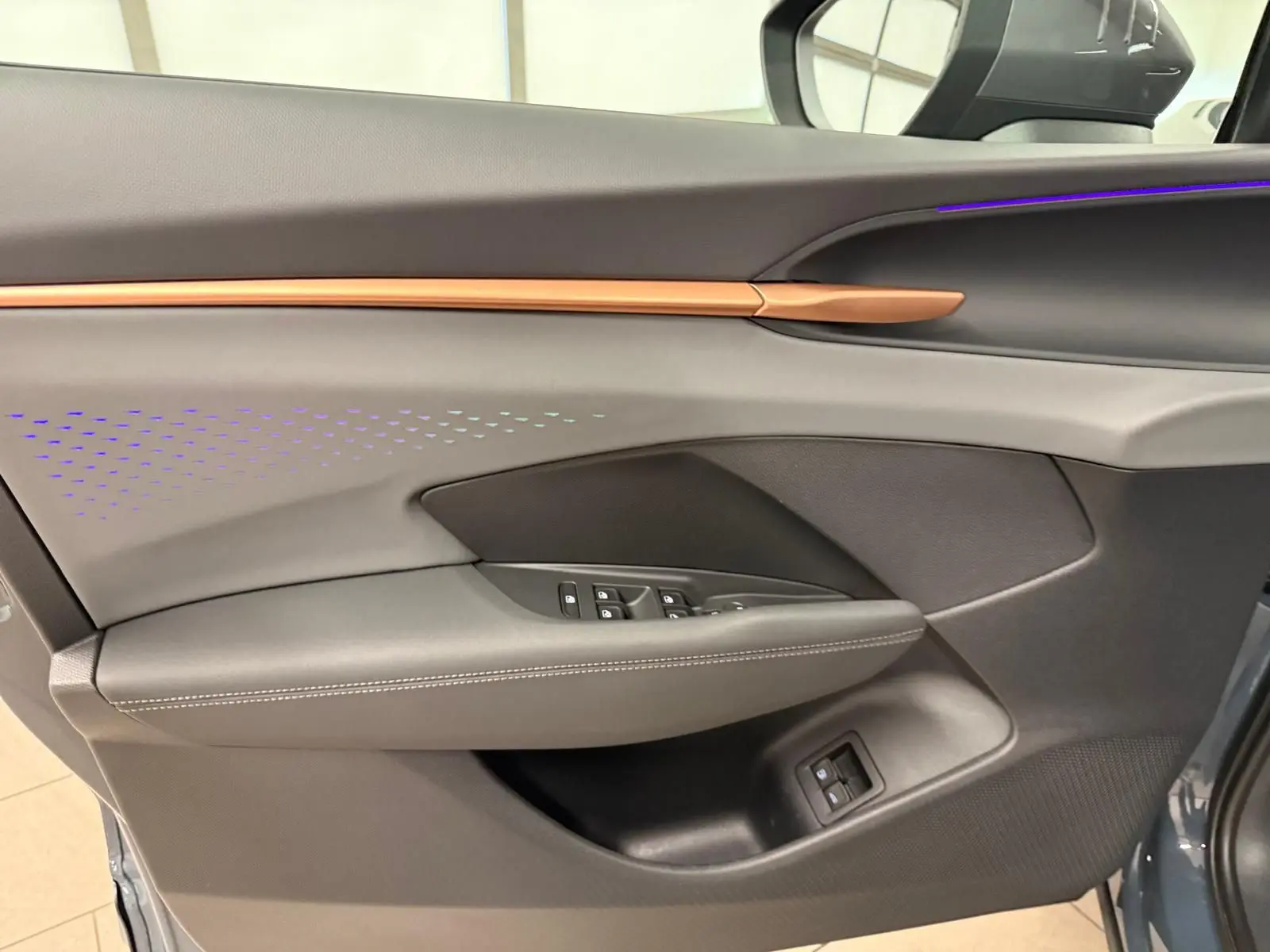 Vue intérieure côté gauche de la porte avant d'une CUPRA TERRAMAR 2025, avec garniture noire et insert cuivré.