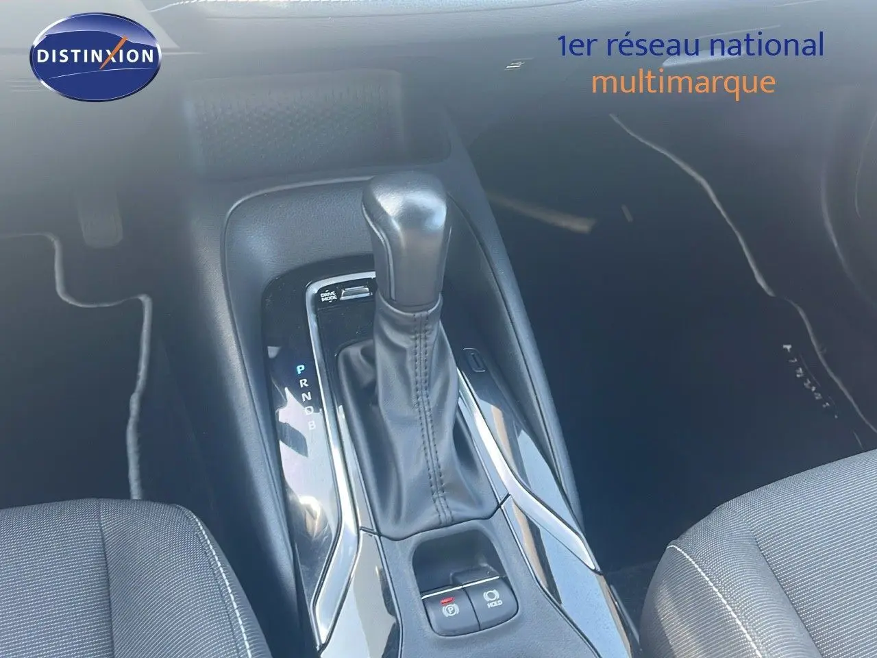 Le levier de vitesse automatique en cuir noir de la Toyota Corolla hybride 2023, vue intérieure centrée sur la console centrale.