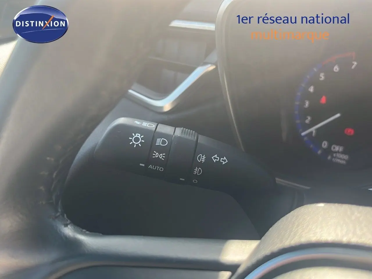 Gros plan sur la commande des phares et clignotants à gauche du volant d'une Toyota Corolla blanche 2023.