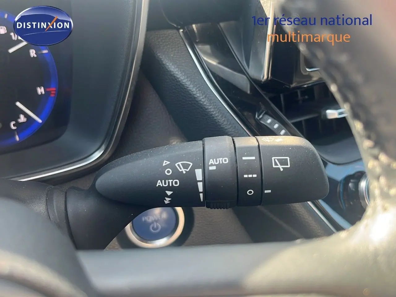 Gros plan sur la commande d’essuie-glace automatique à droite du volant dans l’habitacle d’une Toyota Corolla blanche 2023.