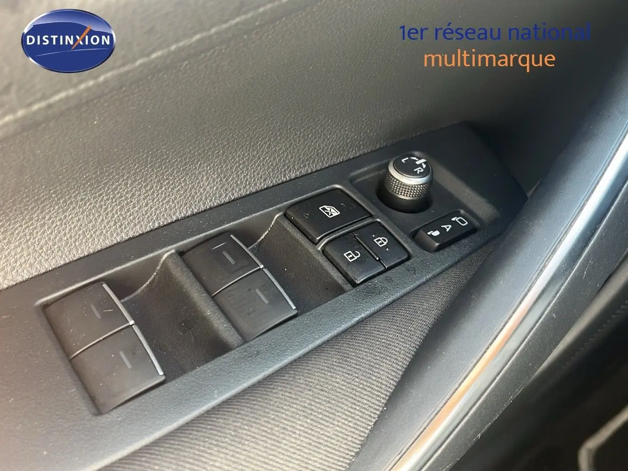 Gros plan sur les commandes électriques de lève-vitres et rétroviseurs côté conducteur d'une Toyota Corolla blanche 2023.