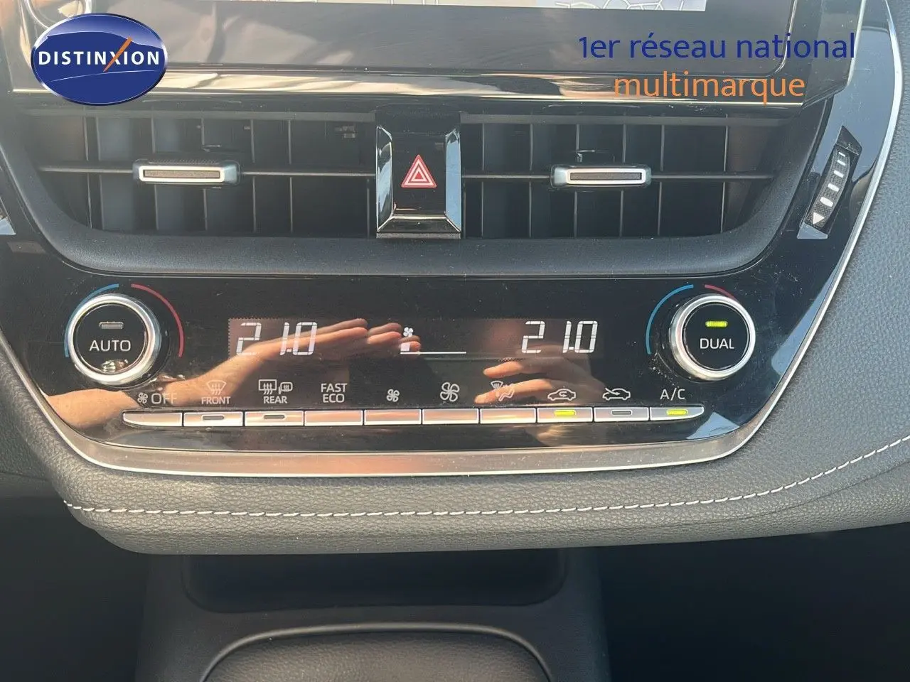 Panneau de commande de climatisation automatique de la Toyota Corolla blanche 2023, affichant 21°C en mode dual.