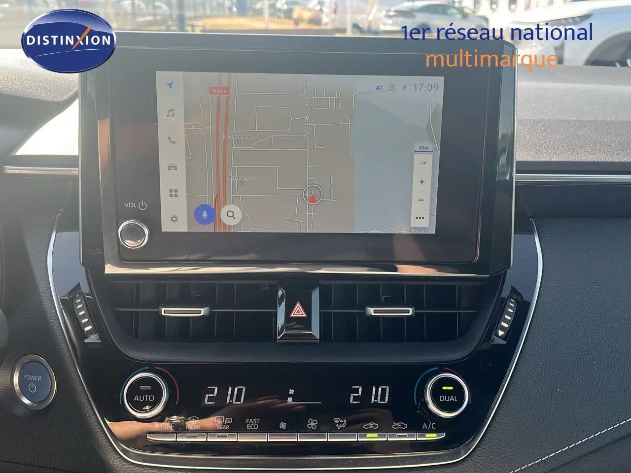 Vue rapprochée de l'écran tactile et de la console centrale noire de la Toyota Corolla blanche hybride 2023.