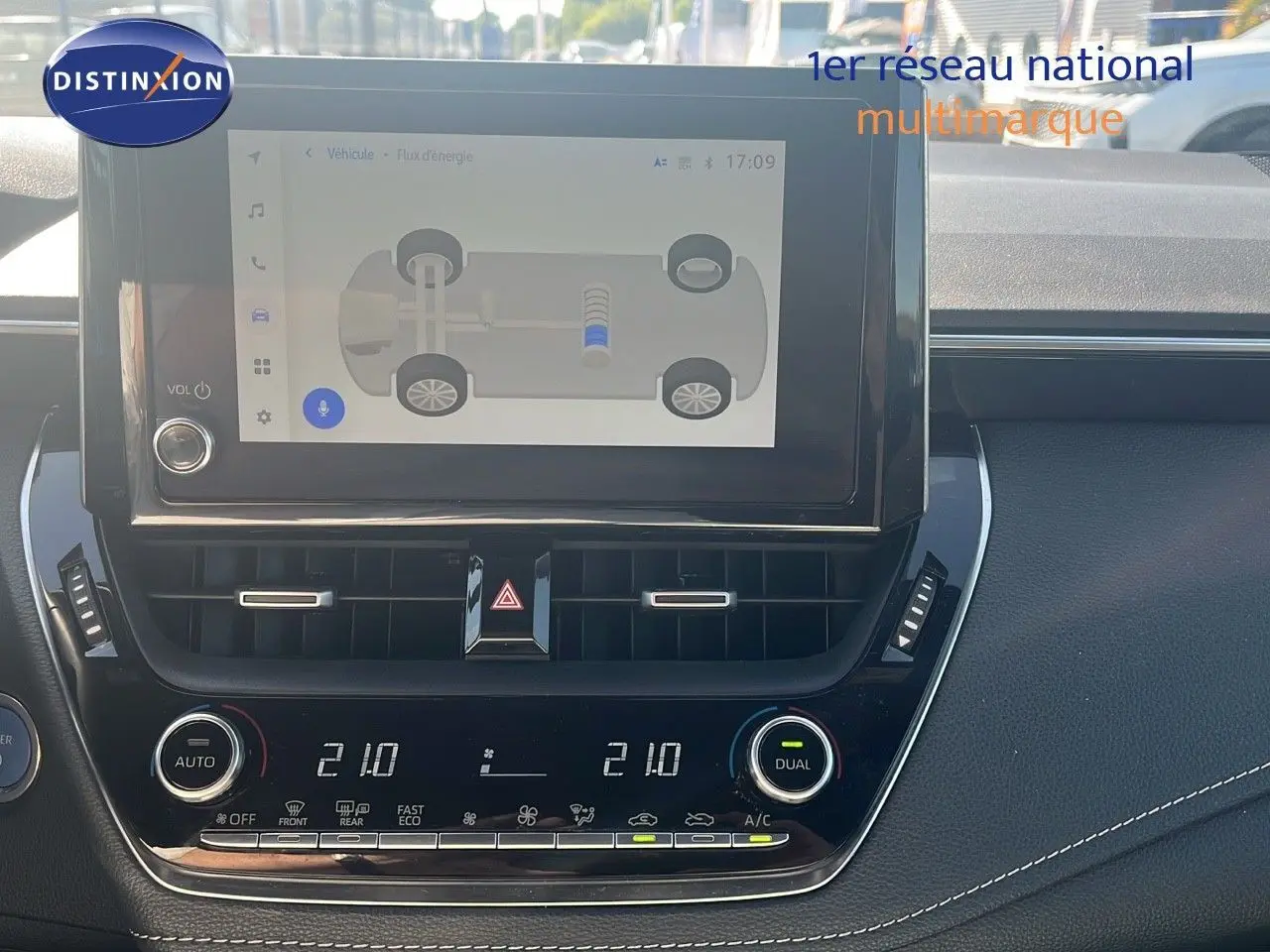 Intérieur de la Toyota Corolla 1.8 HSD 122CH 2023 montrant l'écran tactile et la console centrale noire avec climatisation digitale.