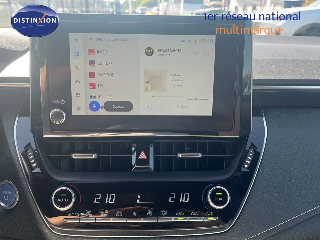 Tableau de bord de Toyota Corolla hybride 2023 avec écran tactile et commandes de climatisation en vue frontale rapprochée.