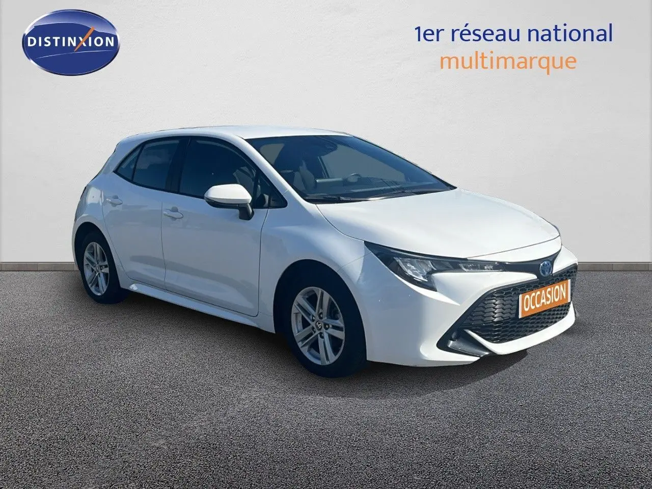 Toyota Corolla 1.8 HSD blanc pur vue 3/4 avant droit avec calandre noire et jantes alliage 16 pouces