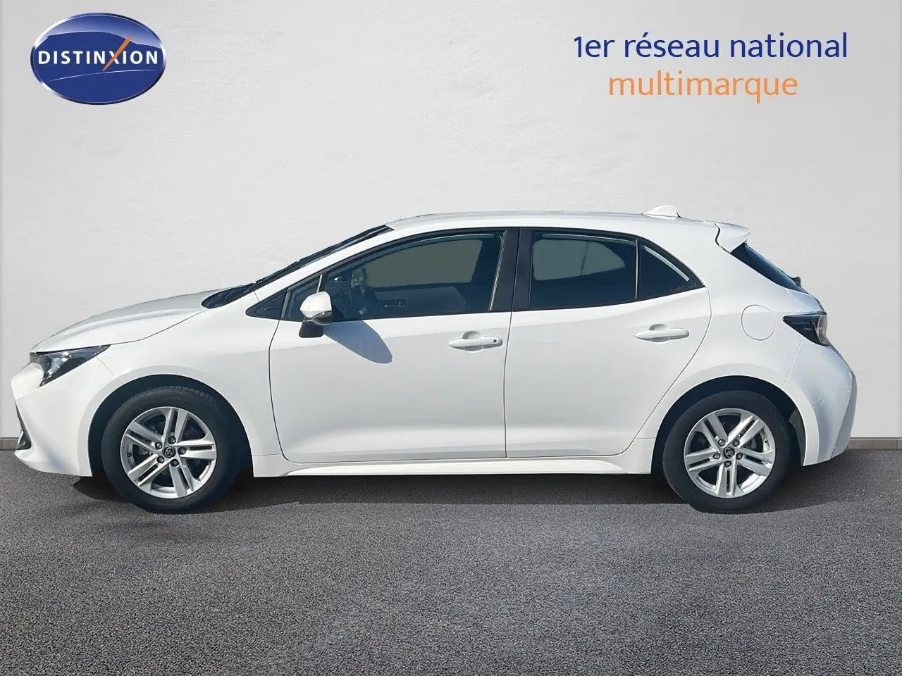 Profil droit d'une Toyota Corolla blanche pure hybride 2023 avec jantes alliage et carrosserie compacte cinq portes.