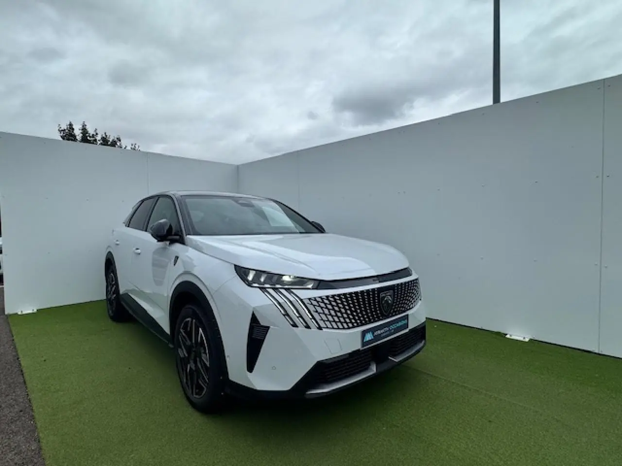 Peugeot 3008 blanc nacré avec toit noir, vue 3/4 avant droit, calandre distinctive et jantes alliage noires.