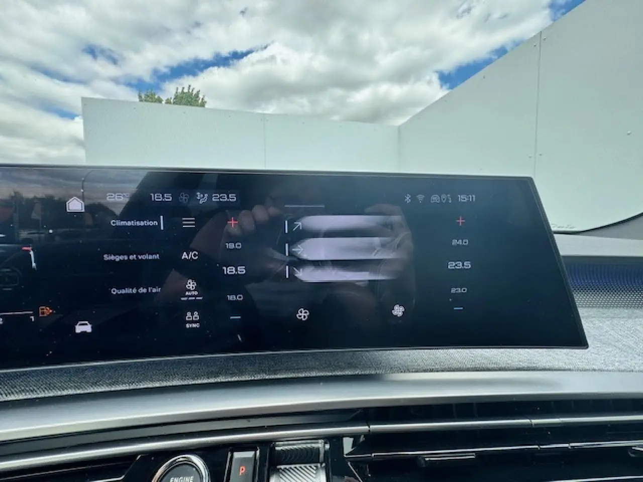 Écran tactile panoramique du tableau de bord du Peugeot 3008 blanc nacré 2024 affichant la climatisation.