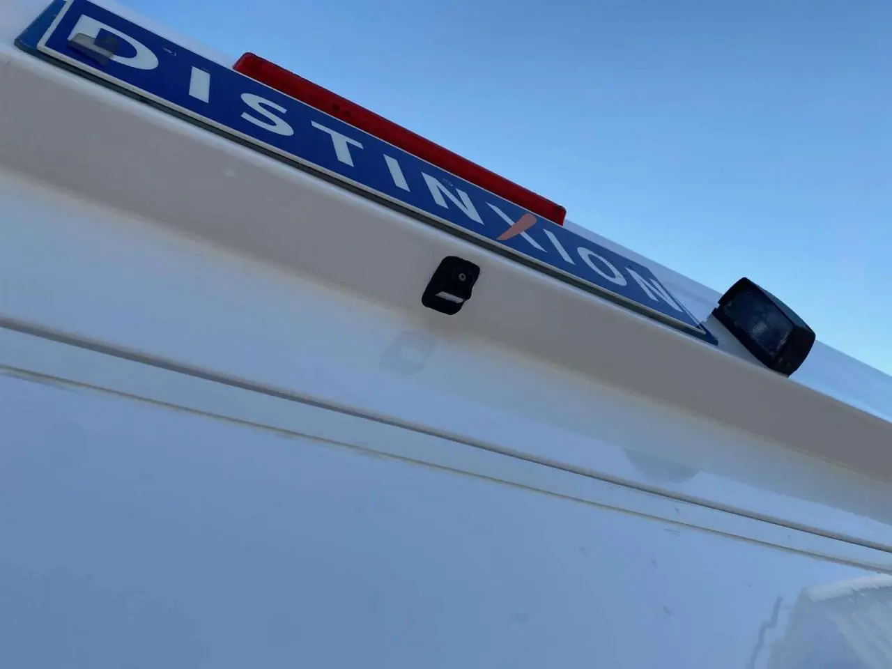 Gros plan sur la caméra de recul et la plaque arrière d'un Opel Movano Fourgon blanc vue de l'arrière en légère contre-plongée.