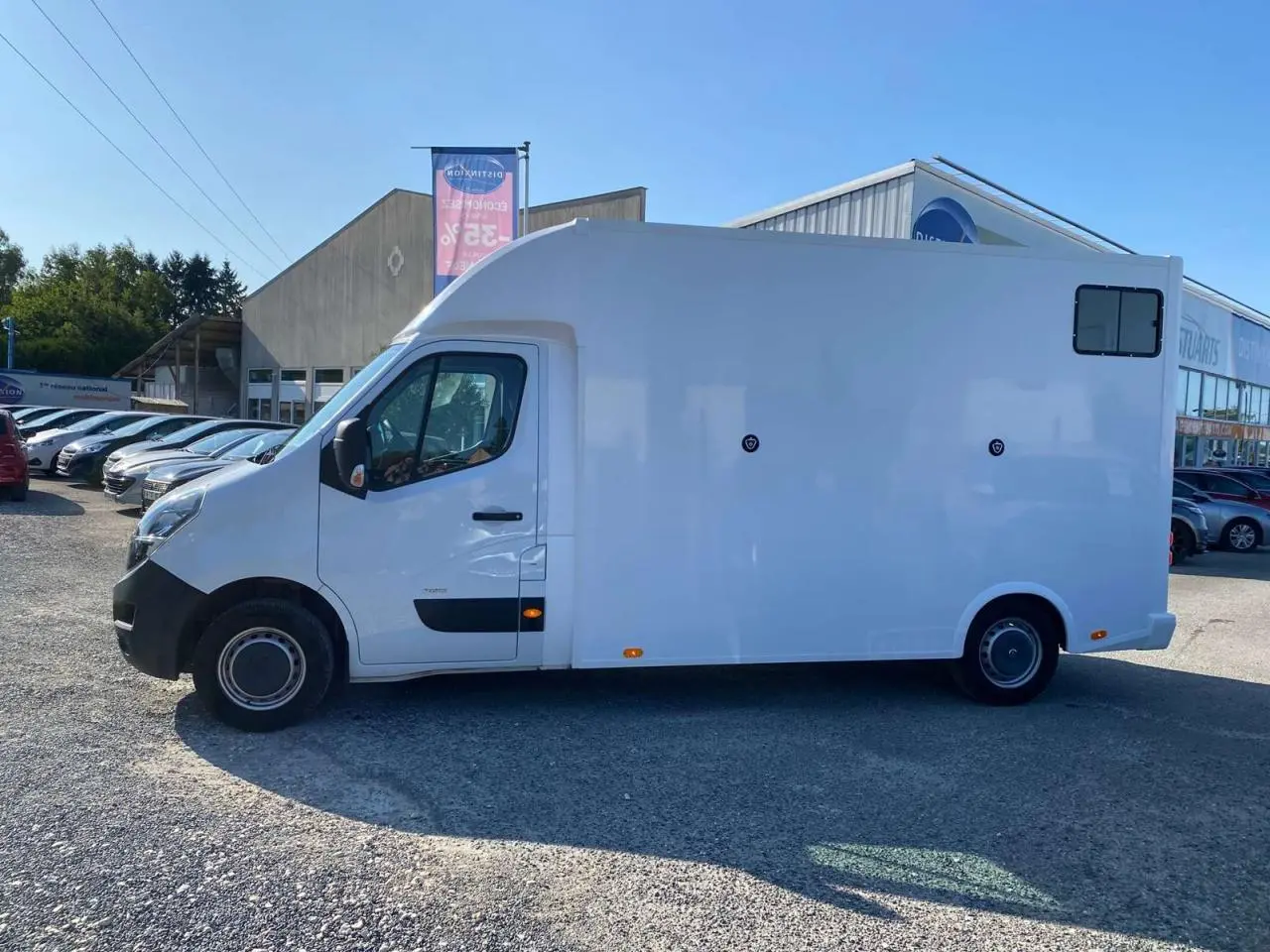 Profil côté gauche d'un Opel Movano Fourgon blanc 2021 avec capucine et petite fenêtre arrière.
