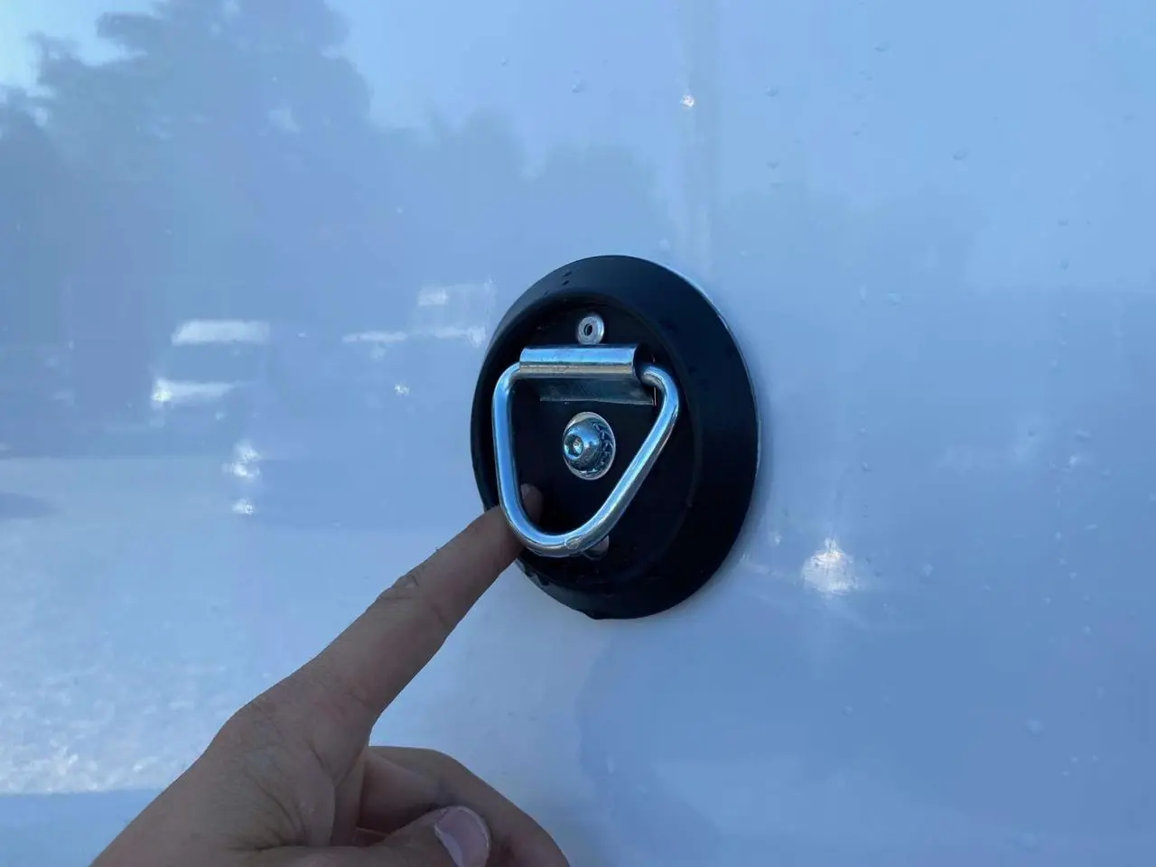 Gros plan sur une main touchant un anneau d'arrimage fixé sur la carrosserie blanche d'un Opel Movano Fourgon.