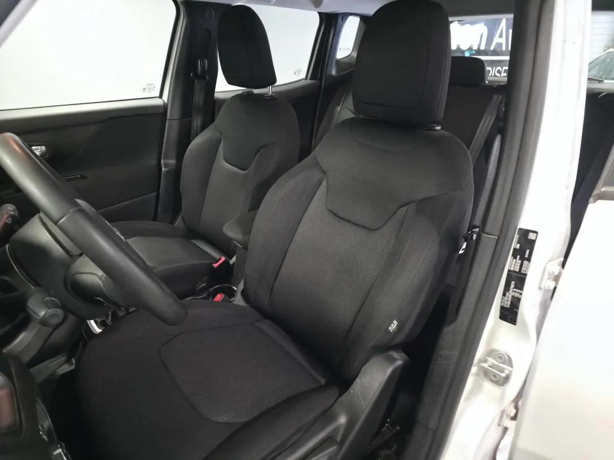 Intérieur du Jeep Renegade 2018 blanc, vue côté gauche sur les sièges avant noirs avec appuie-têtes réglables.