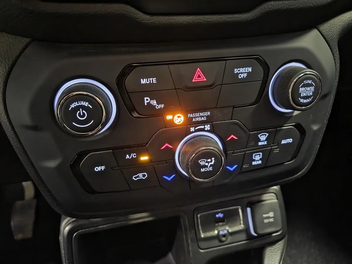 Gros plan sur la console centrale noire du Jeep Renegade 2018 avec commandes climatisation et multimédia éclairées.