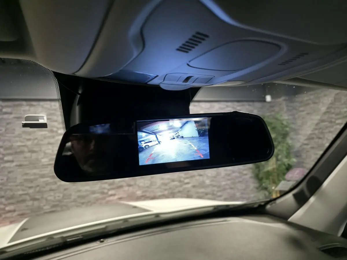 Vue intérieure du rétroviseur central numérique du Jeep Renegade blanc, affichant la caméra de recul en fonctionnement.