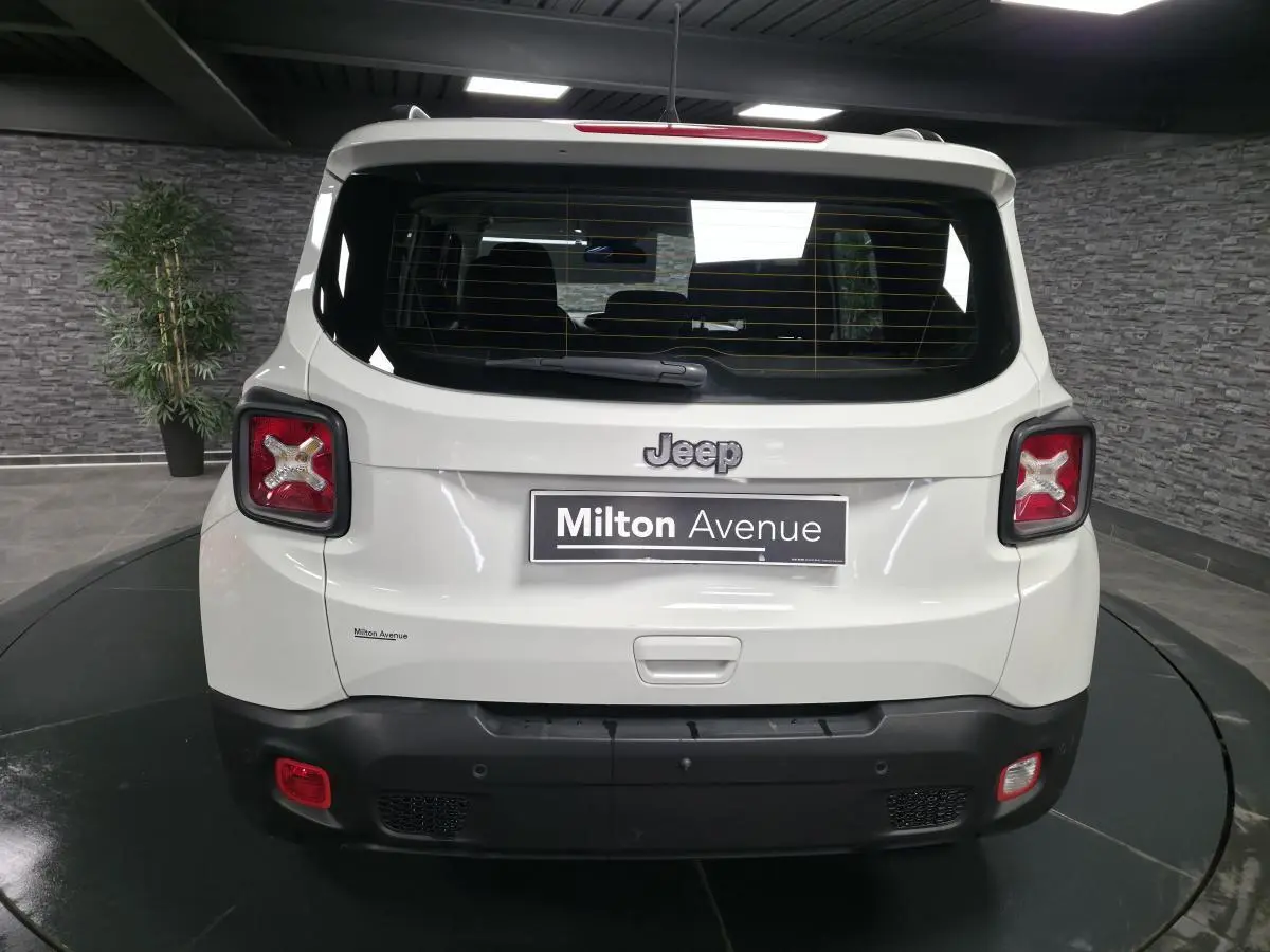 Vue arrière du Jeep Renegade blanc 2018 avec feux arrière en forme de croix et pare-chocs noir contrastant.