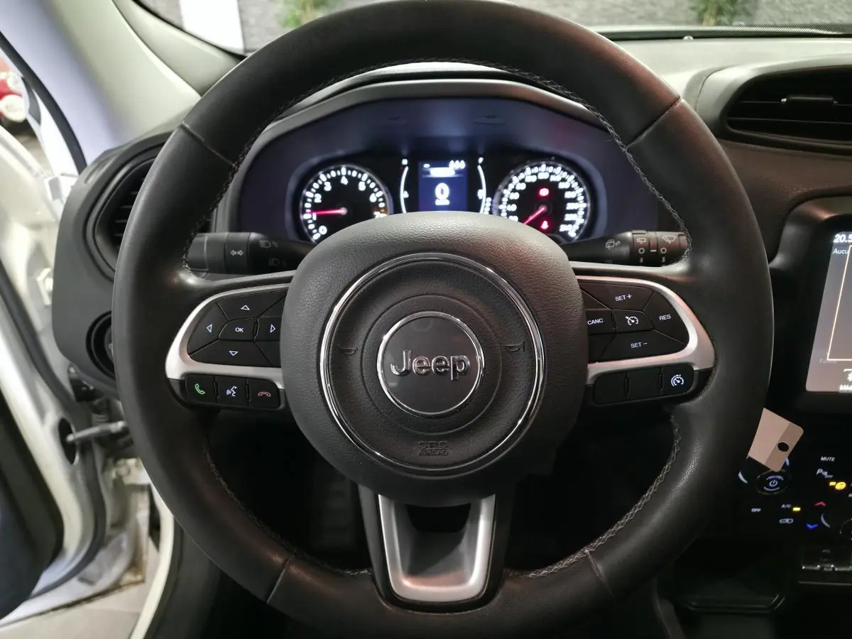 Volant cuir multifonctions Jeep Renegade blanc 2018 vu de face avec tableau de bord et commandes visibles.