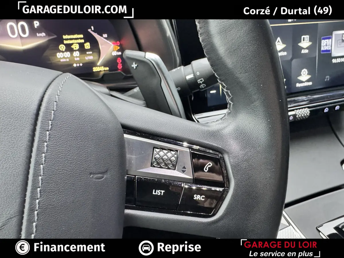 Vue rapprochée du volant noir avec commandes multifonctions et tableau de bord numérique du DS7 Crossback bleu 2024.