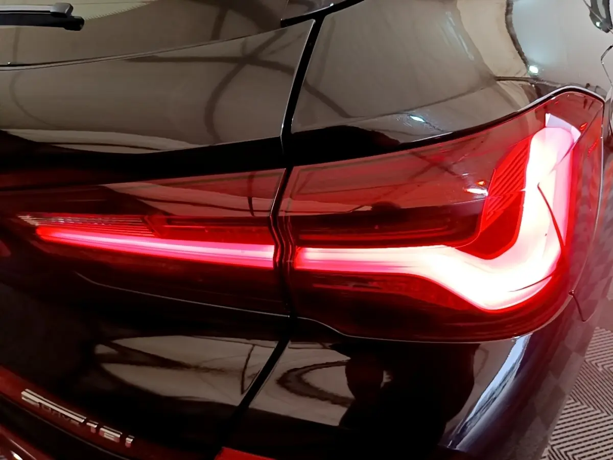 Gros plan sur le feu arrière droit allumé d’un BMW X2 sDrive18i Lounge noir 2023.