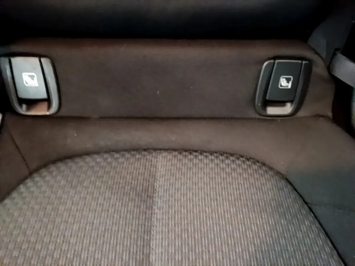 Gros plan sur la banquette arrière noire du BMW X2 sDrive18i Lounge 2023 avec commandes de rabattement des sièges visibles.