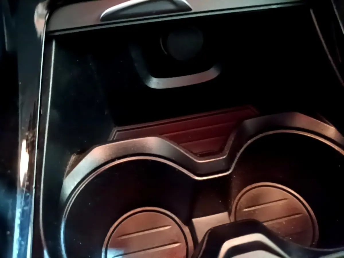 Gros plan sur les porte-gobelets noirs du BMW X2 sDrive18i Lounge 2023, intérieur moderne avec finition brillante.