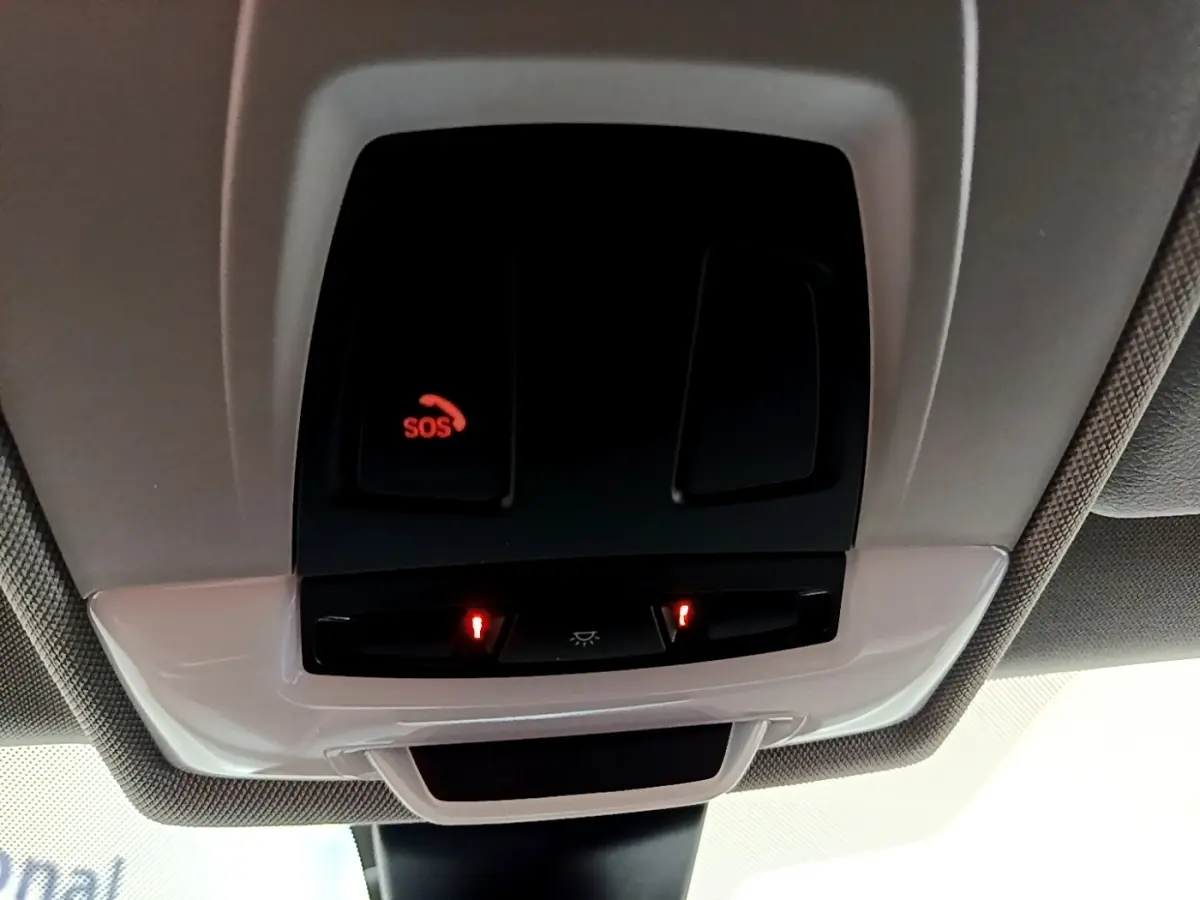 Gros plan sur le plafonnier intérieur avec bouton SOS illuminé en rouge dans une BMW X2 noire 2023.
