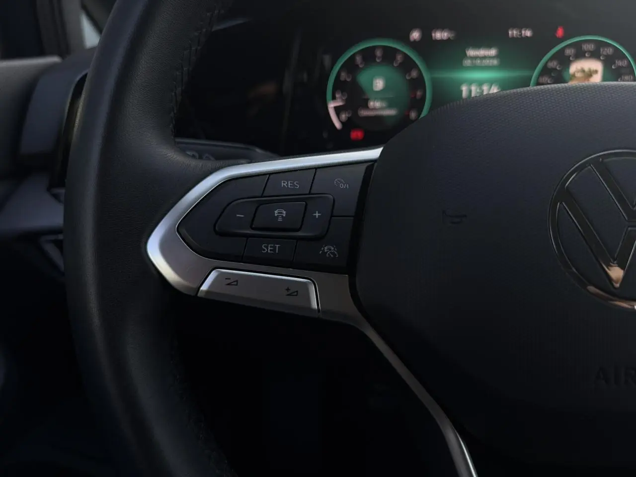 Gros plan sur le volant multifonction noir de la Volkswagen Golf VIII 2024 avec commandes de régulateur adaptatif.