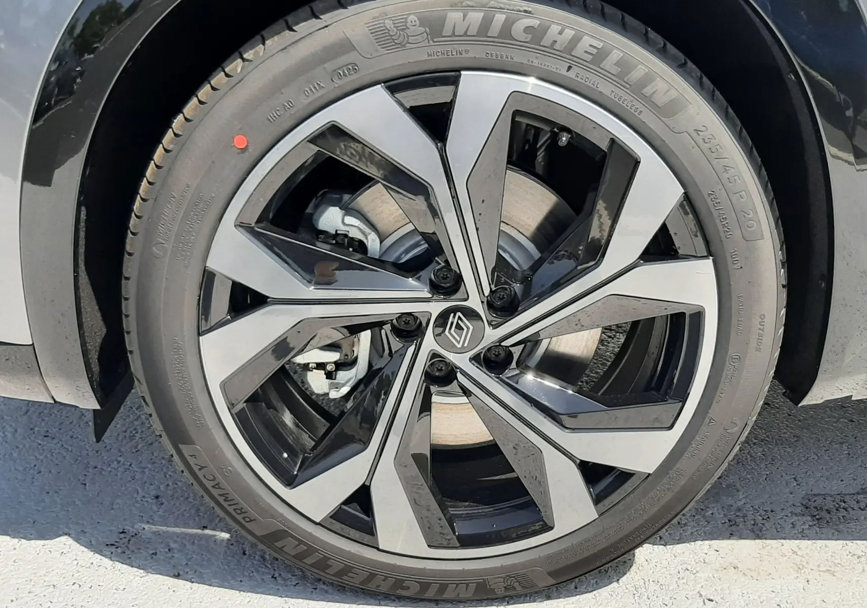 Gros plan sur la jante alliage bicolore et pneu Michelin du Renault Espace gris schiste métal, version hybride 7 places.