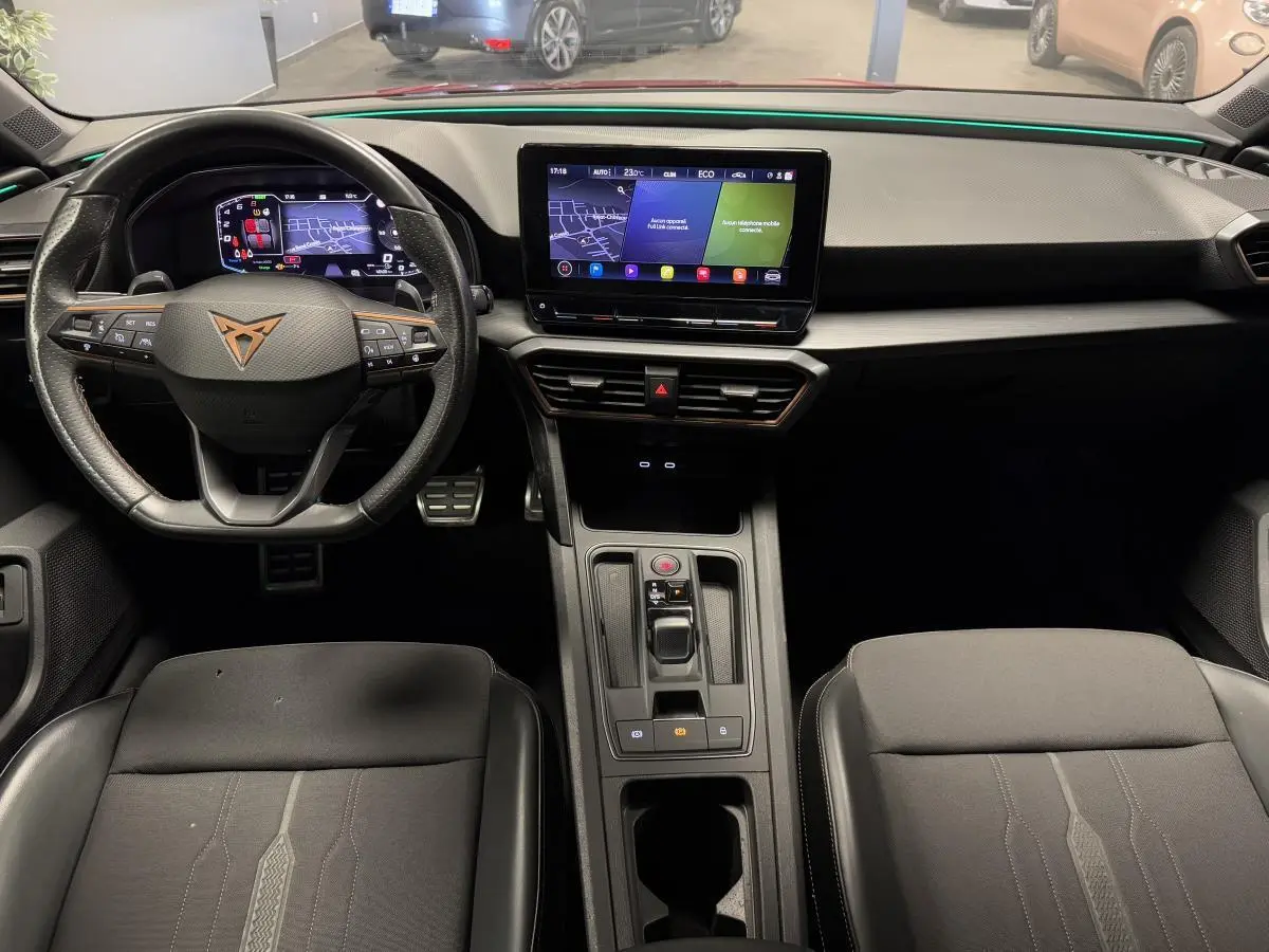 Intérieur avant du CUPRA Leon Sportstourer 1.4 e-Hybrid 2021, tableau de bord noir avec écran tactile central et volant multifonction.