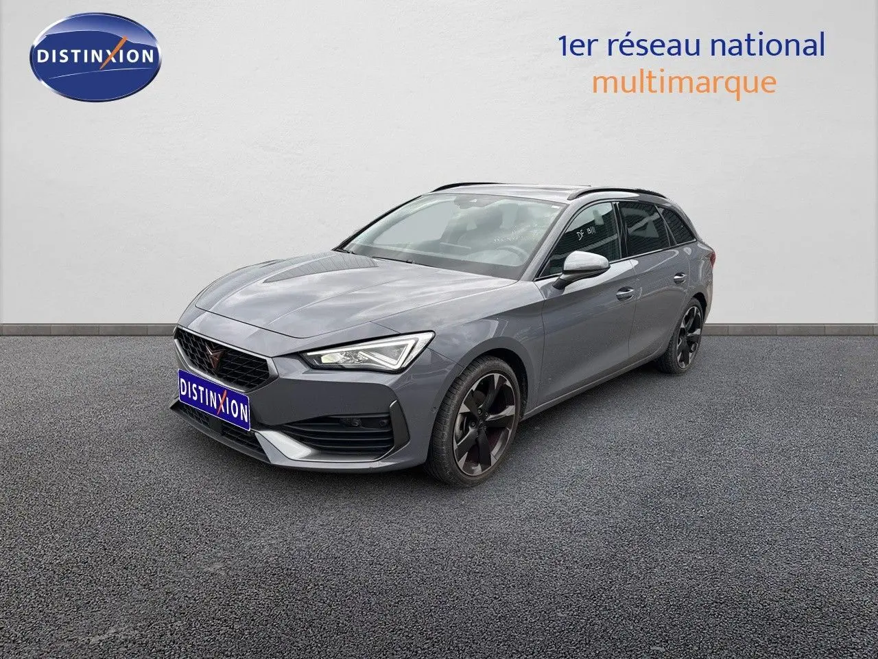 Vue 3/4 avant droite d'une CUPRA LEON ST gris Graphene métal avec jantes noires biton et calandre distinctive.