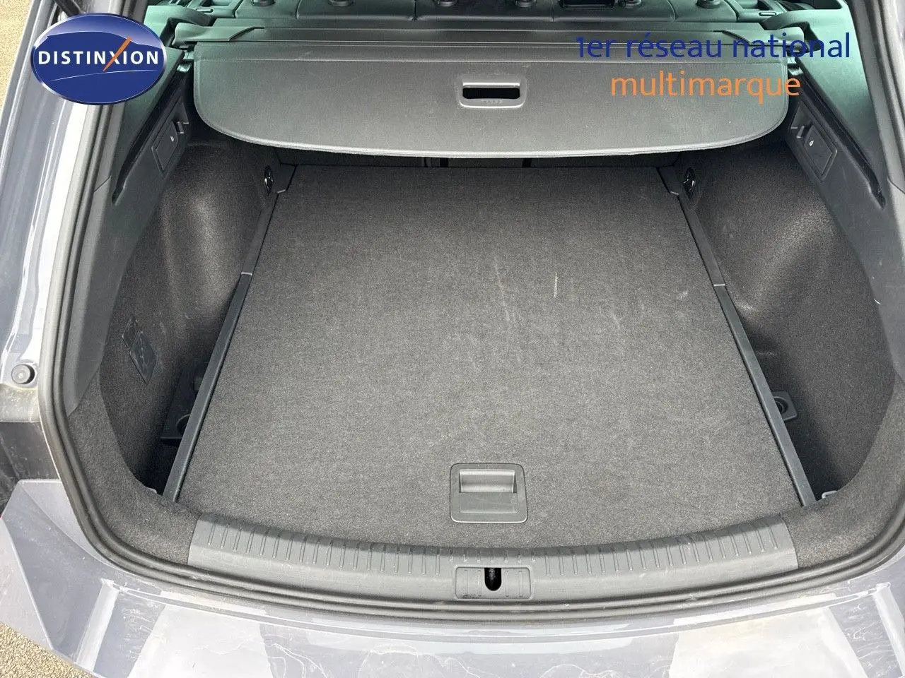 Coffre ouvert vu de l'arrière d'une CUPRA LEON ST 1.5 ETSI gris Graphene Metal, espace de chargement spacieux et propre.