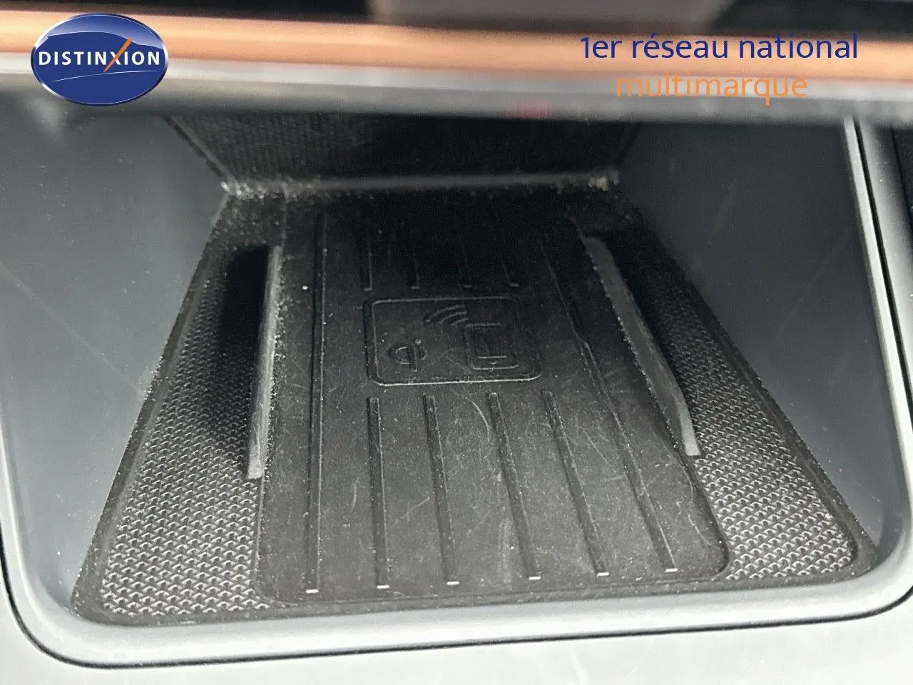 Gros plan sur le chargeur sans fil intégré au centre de la console intérieure de la CUPRA LEON ST gris Graphene Metal 2024.