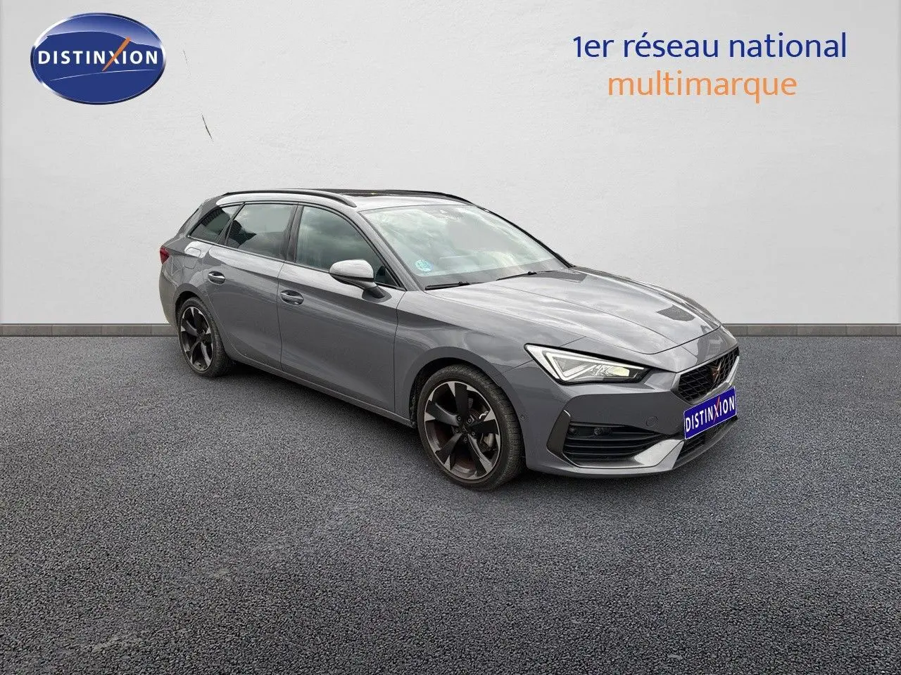 Vue 3/4 avant droite d'une CUPRA LEON ST 2024 gris Graphene Metal avec jantes noires bicolores et toit panoramique.