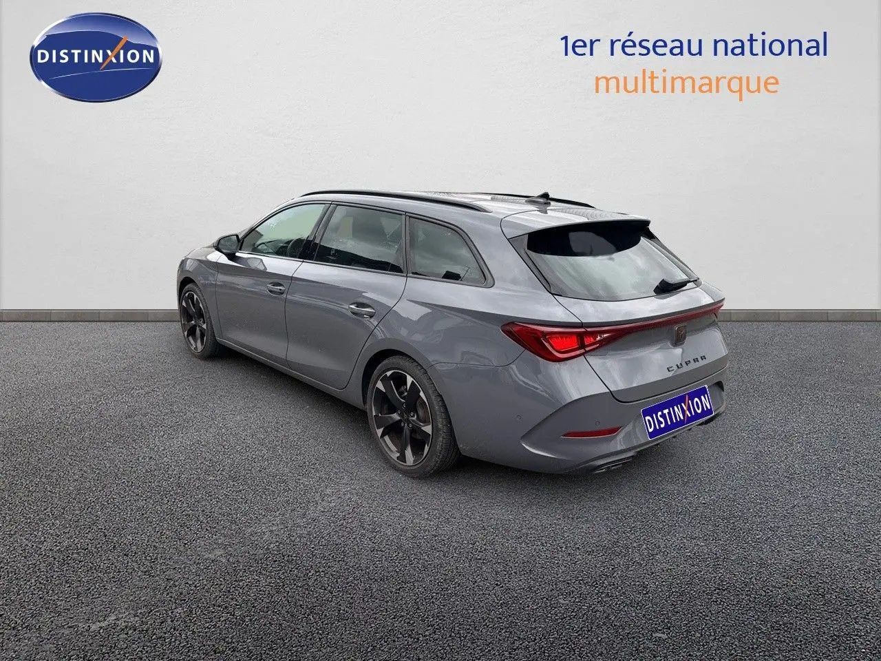 Vue 3/4 arrière droite d'une CUPRA LEON ST gris Graphene Metal avec jantes bi-ton et feux arrière LED distinctifs.