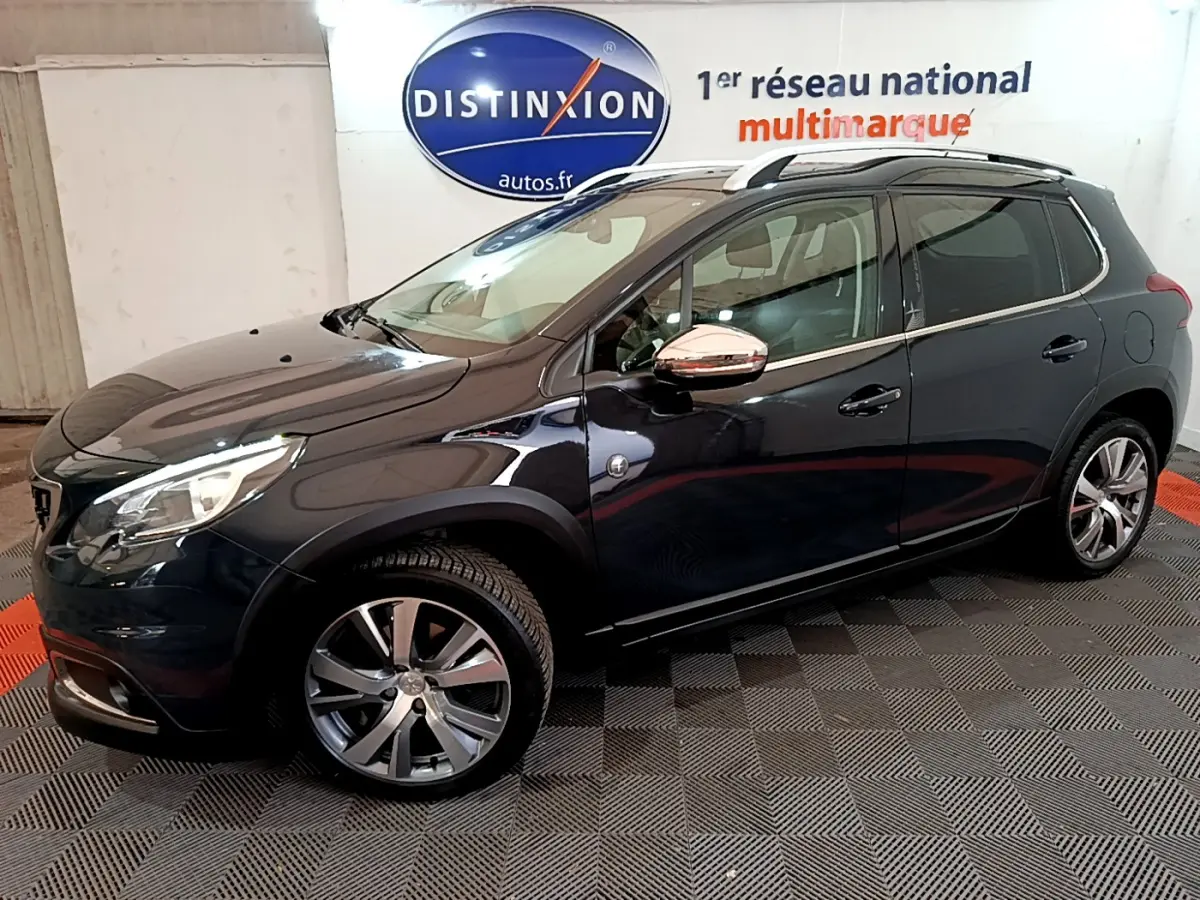 Peugeot 2008 gris foncé vue de profil côté gauche, avec jantes alliage et rétroviseurs chromés.