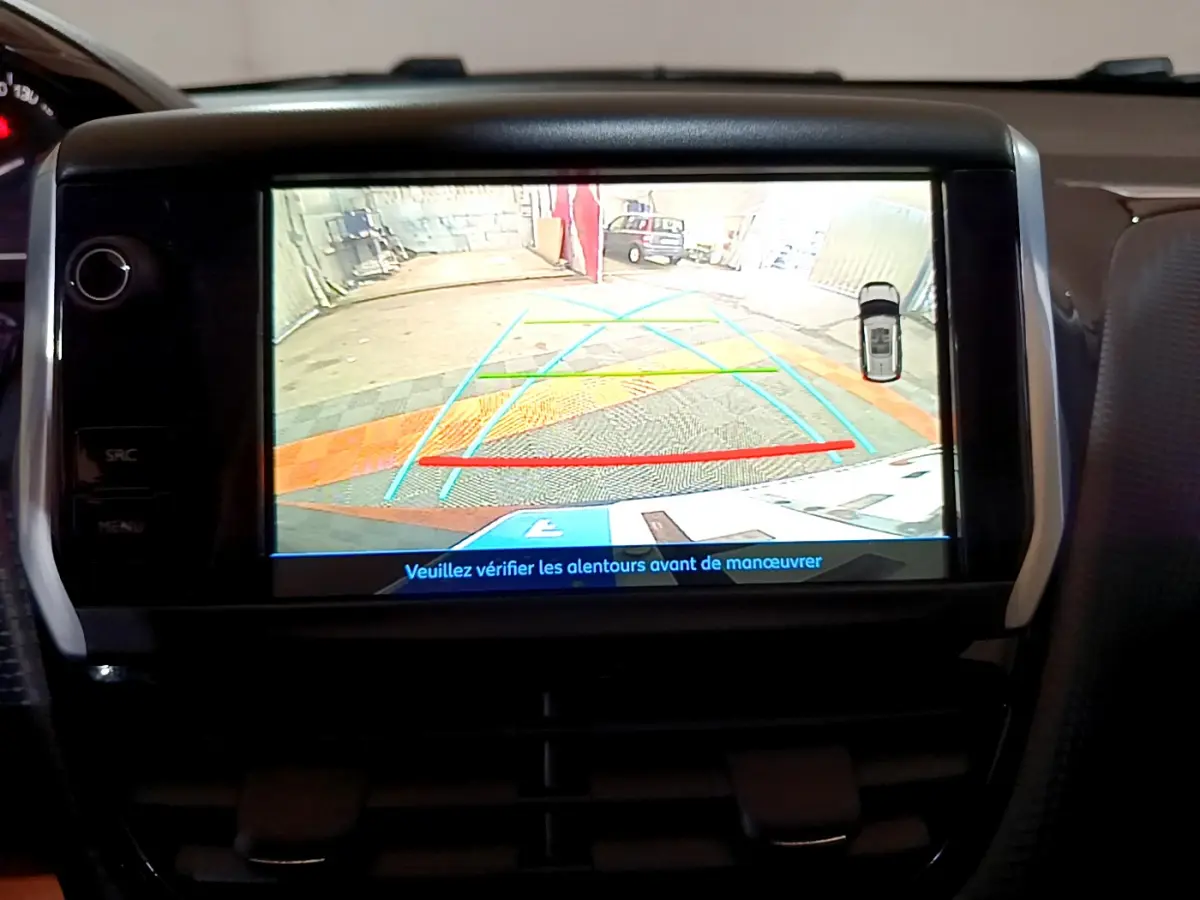 Écran tactile du tableau de bord du Peugeot 2008 affichant la caméra de recul avec guidage coloré en intérieur véhicule.