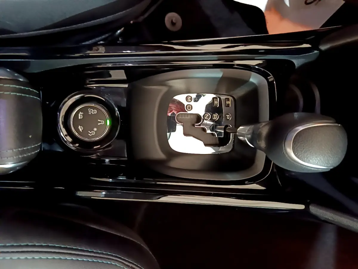 Le levier de vitesses automatique et la molette de sélection de mode de conduite du Peugeot 2008 gris foncé vus de dessus.