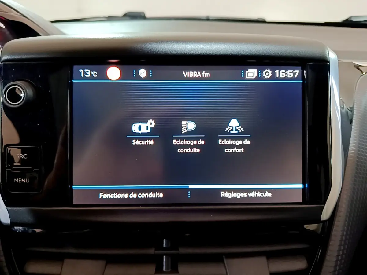 Écran tactile central du tableau de bord du Peugeot 2008 gris foncé, affichant les options de conduite et sécurité.