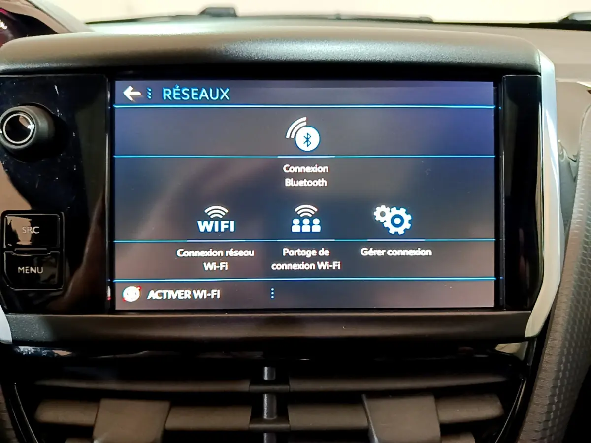 Écran tactile central affichant les options Wi-Fi et Bluetooth dans l'habitacle d'une Peugeot 2008 gris foncé.