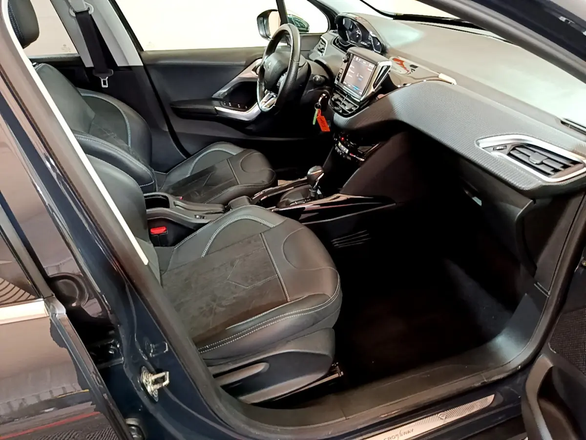 Intérieur avant droit de la Peugeot 2008 gris foncé 2019, avec sièges cuir et tableau de bord tactile.