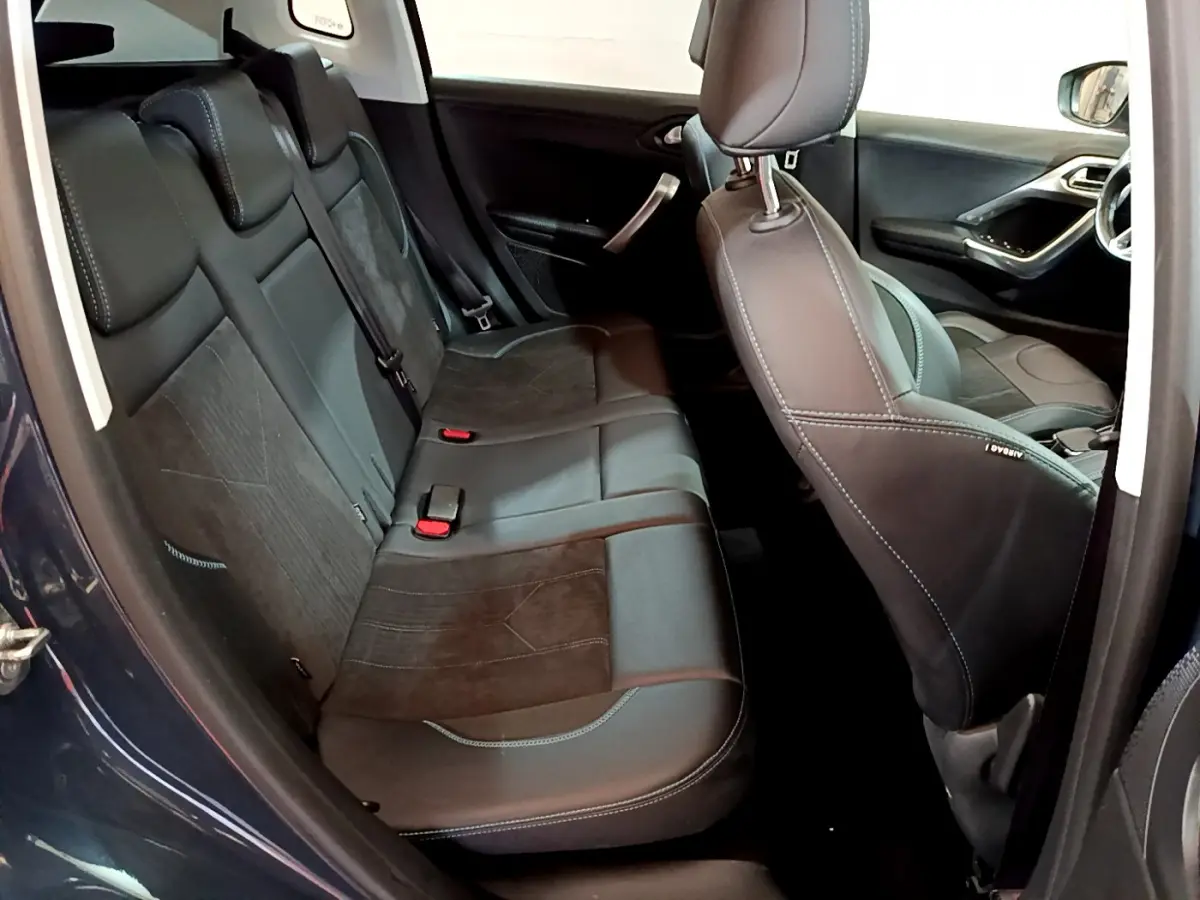 Intérieur arrière du Peugeot 2008 gris foncé, vue côté gauche montrant les sièges en cuir et alcantara avec surpiqûres contrastées.
