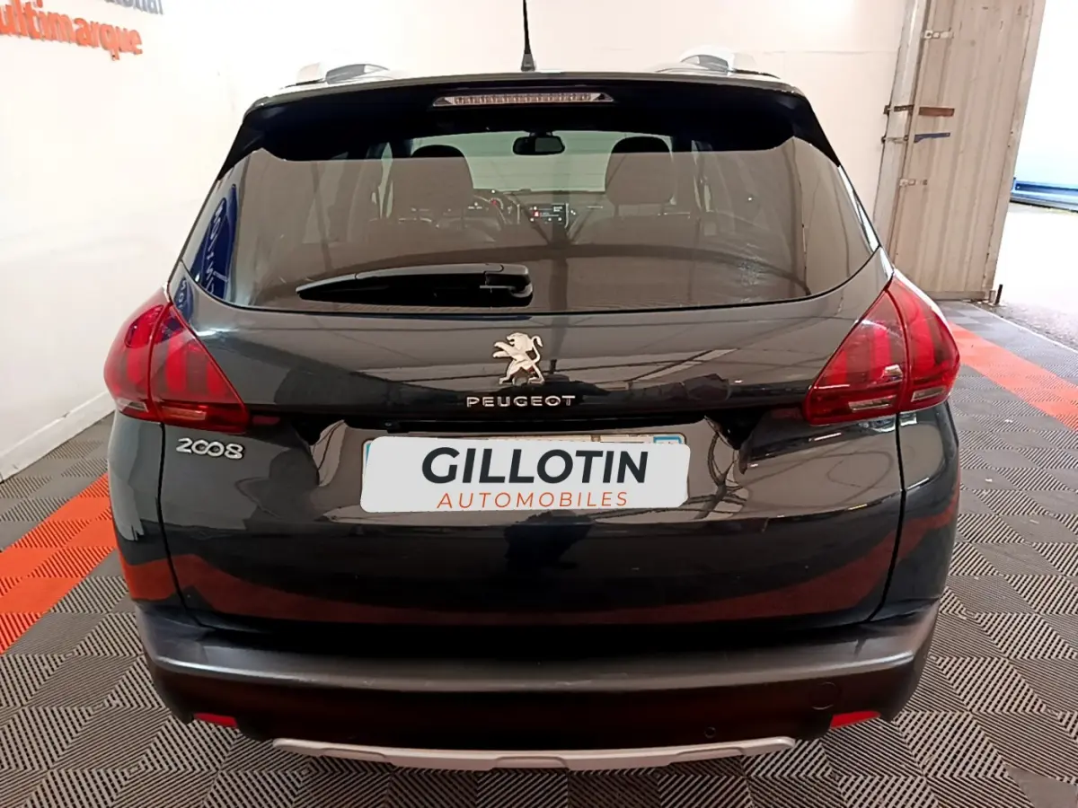 Vue arrière d'un Peugeot 2008 gris foncé avec feux arrière rouges et logo lion centré sur le hayon.