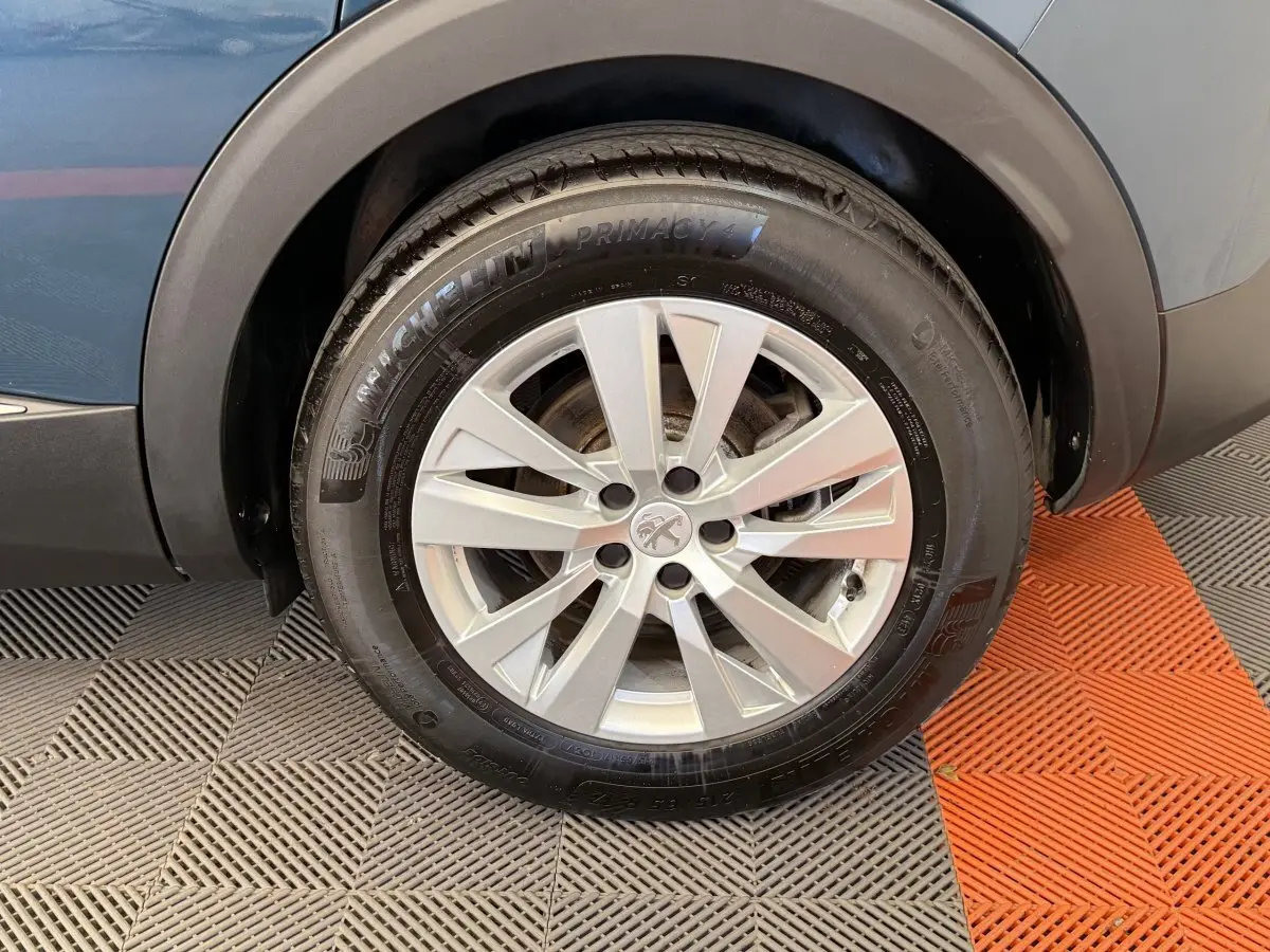 Gros plan sur la roue avant gauche du Peugeot 3008 bleu, avec jante alliage argentée et pneu Michelin Primacy 4.