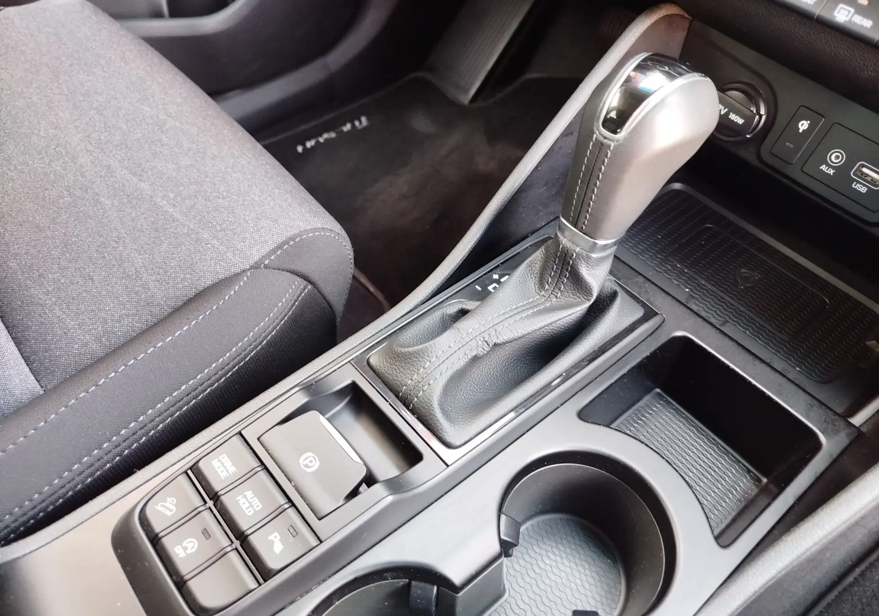 Gros plan sur la console centrale du Hyundai Tucson 2019 Micron Grey, montrant le levier de vitesse automatique et les commandes environnantes.