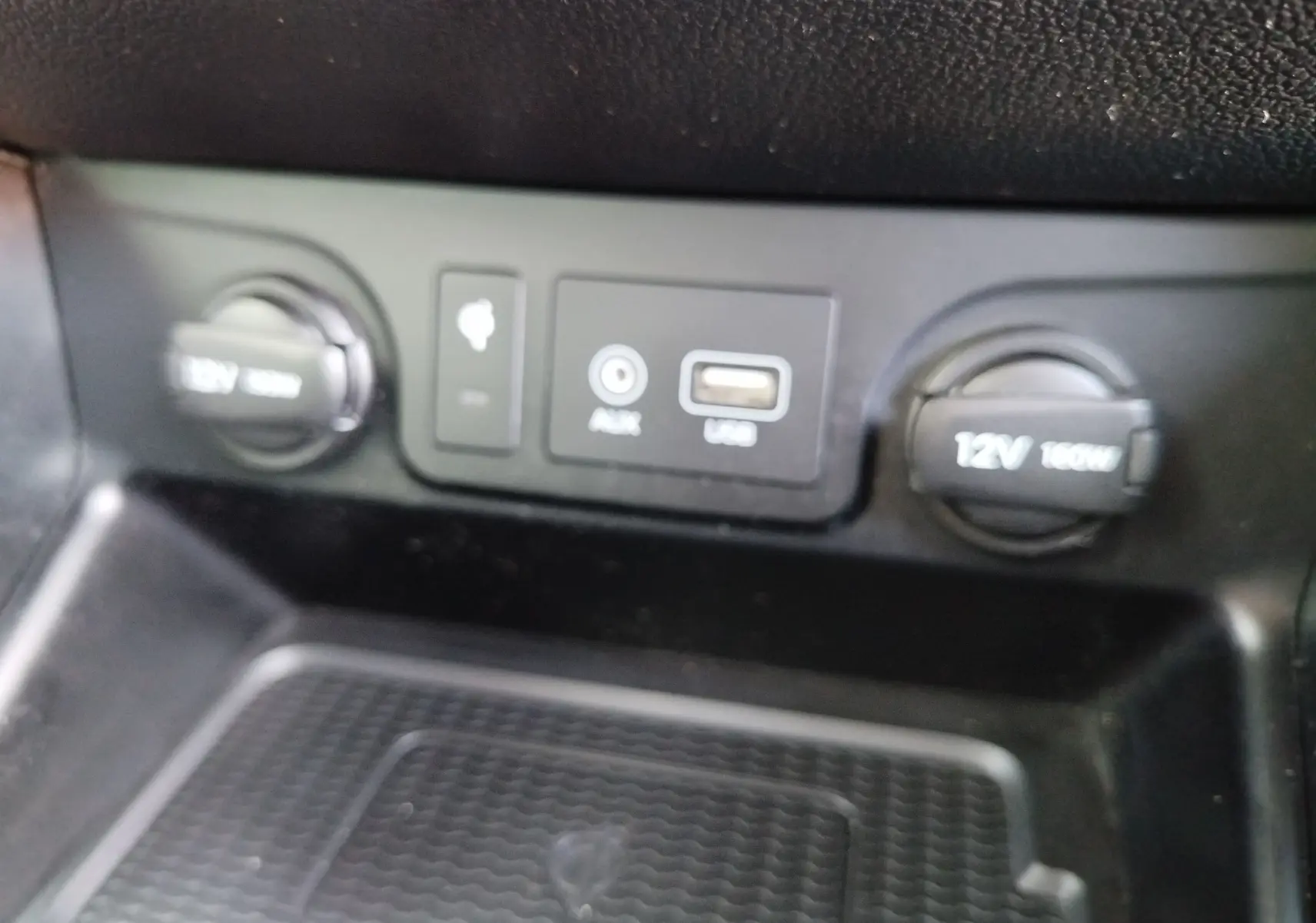 Vue rapprochée des ports USB, AUX et prises 12V du tableau de bord intérieur du Hyundai Tucson gris Micron.