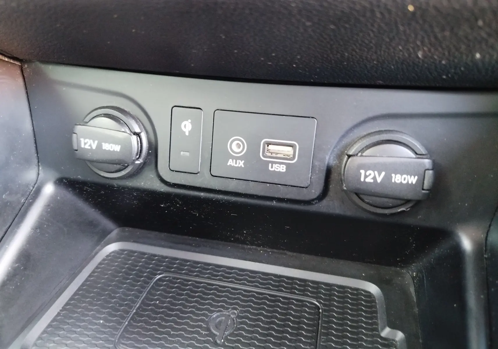 Vue rapprochée du panneau de connectiques USB, AUX, recharge sans fil et prises 12V du Hyundai Tucson Micron Grey 2019.