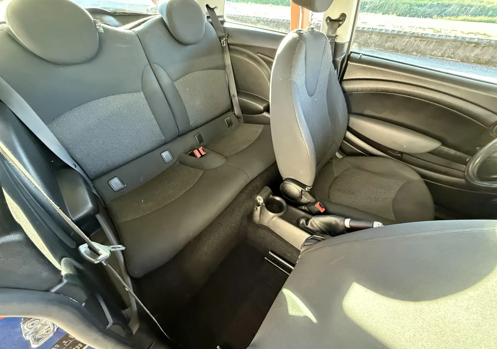 Vue intérieure côté droit de la MINI Cooper 2007 avec sièges tissu gris et console centrale visible.