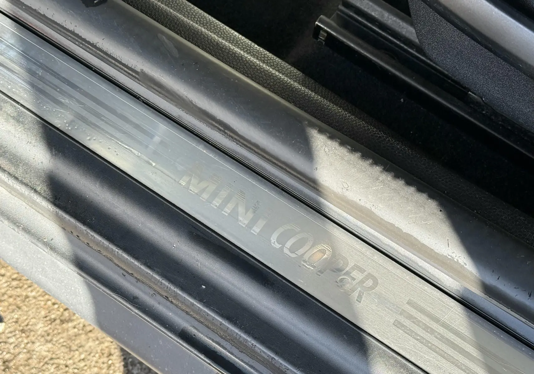 Gros plan sur la plaque de seuil de porte MINI Cooper en métal brossé, avec inscription gravée visible.