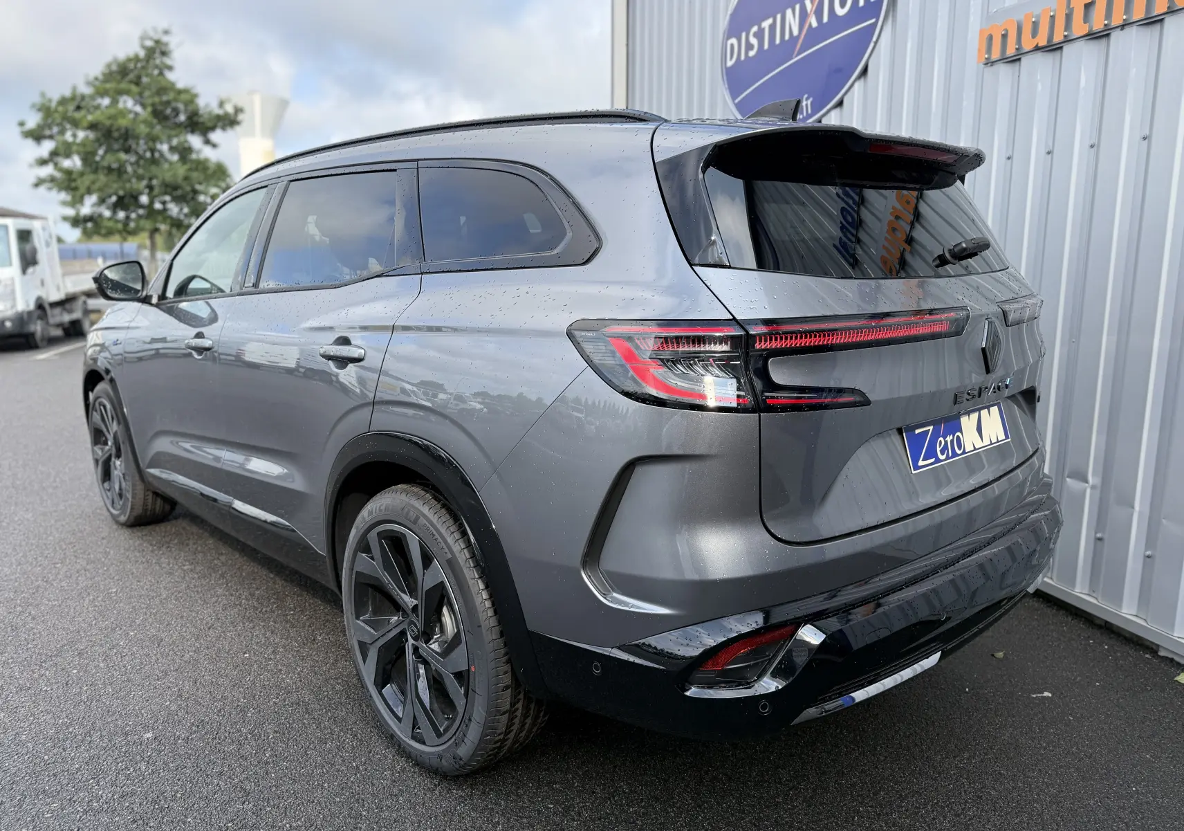 Vue 3/4 arrière droite du Renault Espace gris schiste métal 2025 avec feux LED et jantes noires bicolores.